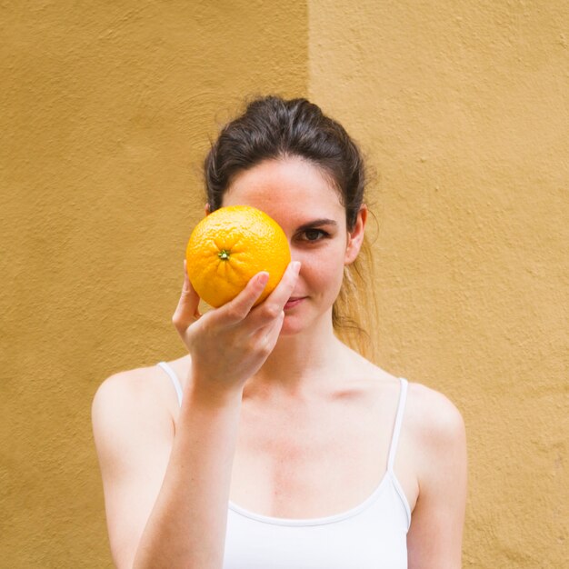 Close up shot woman covering face with orange