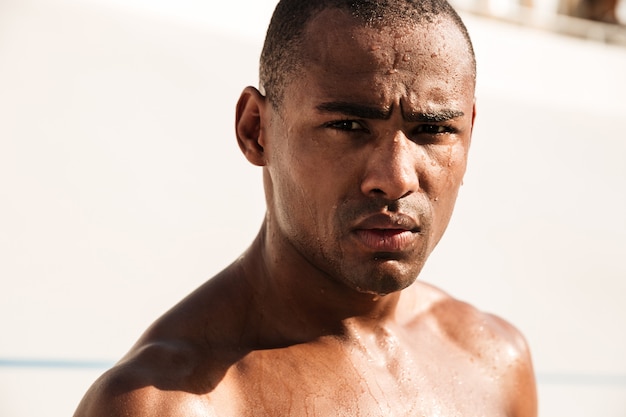 Close-up shot of young african sports man, chilling after running