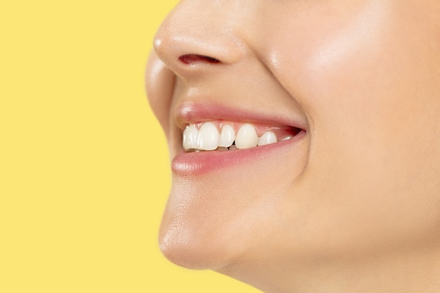 Close up shot of young woman on yellow studio