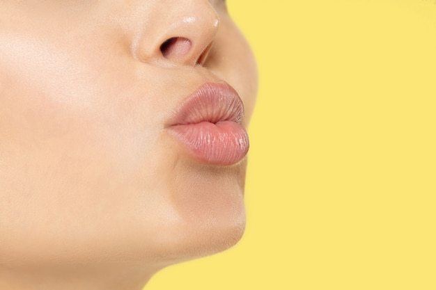 Close up shot of young woman on yellow studio