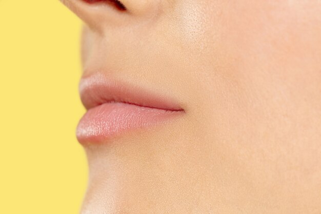 Close up shot of young woman on yellow studio