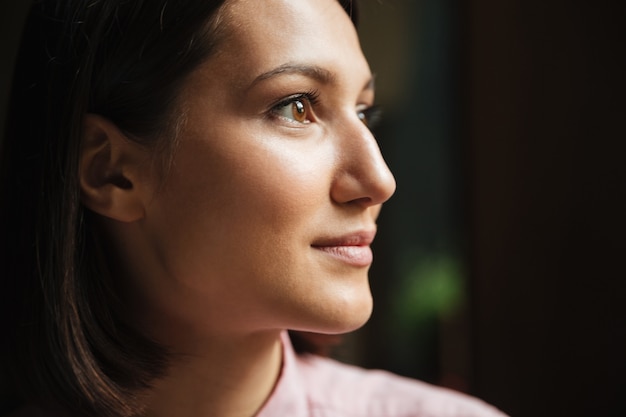 Close up side view of smiling brunette woman