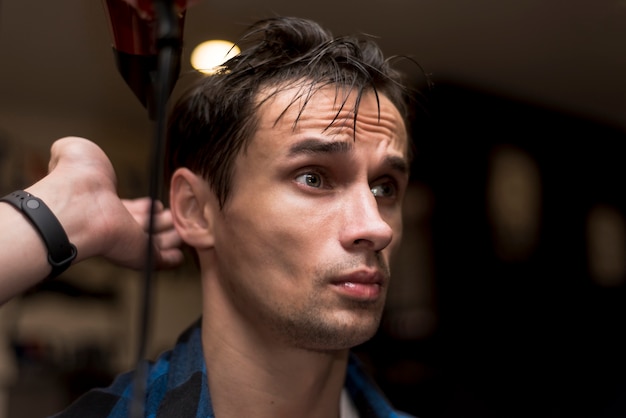 Close up sideways portrait of a man at barbershop