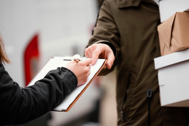 Foto gratuita primo piano di firma per la consegna del pacco