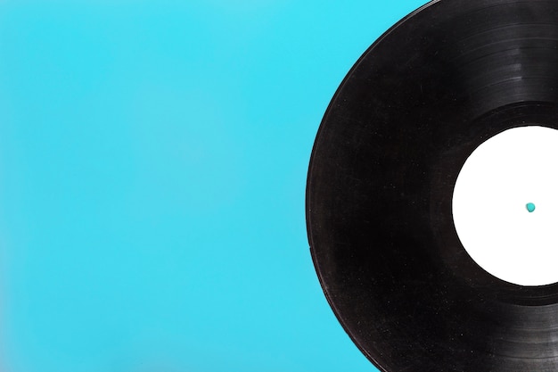 Close-up of single circular vinyl record on blue background