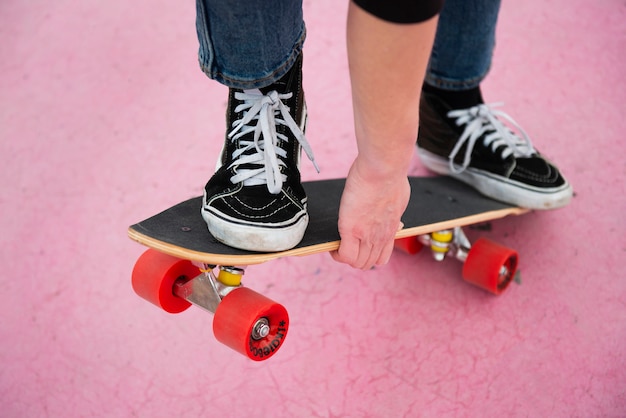 Chiuda sul pattinatore che tiene lo skateboard