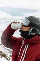Бесплатное фото Крупным планом лыжник, пьющий соду на открытом воздухе