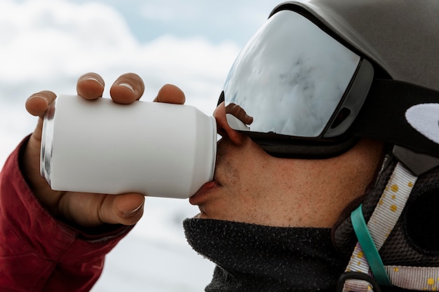 Foto gratuita chiuda in su sciatore che beve soda