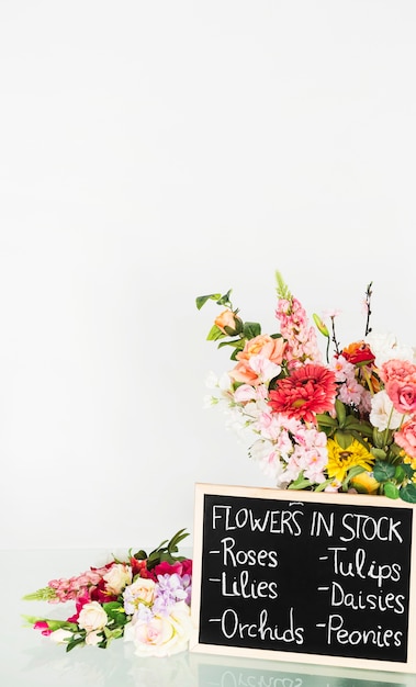 Крупный план сланца, показывая цветы на складе на стеклянном столе в цветочный магазин