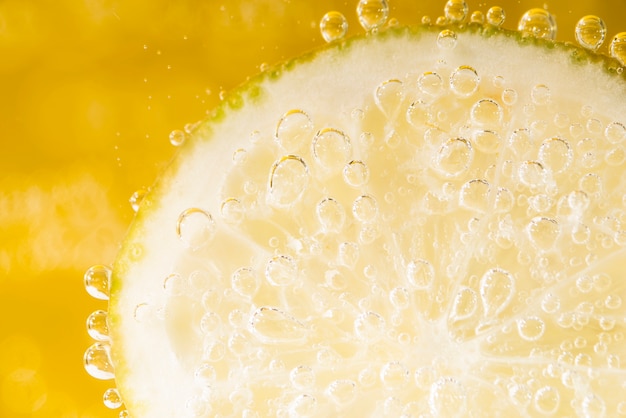 Close-up slice of lemon with water bubbles