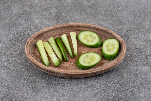 Close up of sliced fresh cucumbers in wooden plate