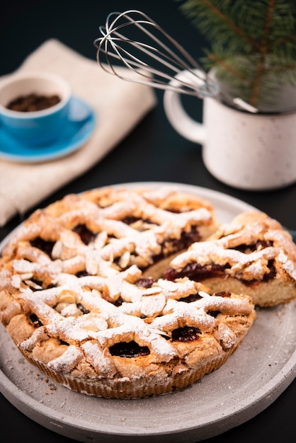 Close-up of sliced pie with defocused coffee beans and pine