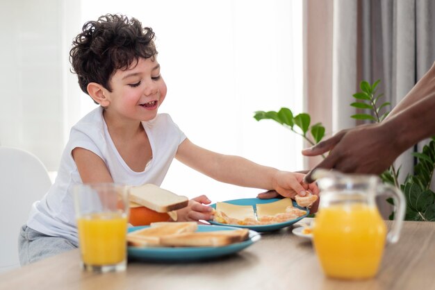 朝食にトーストを食べる小さな男の子にクローズアップ