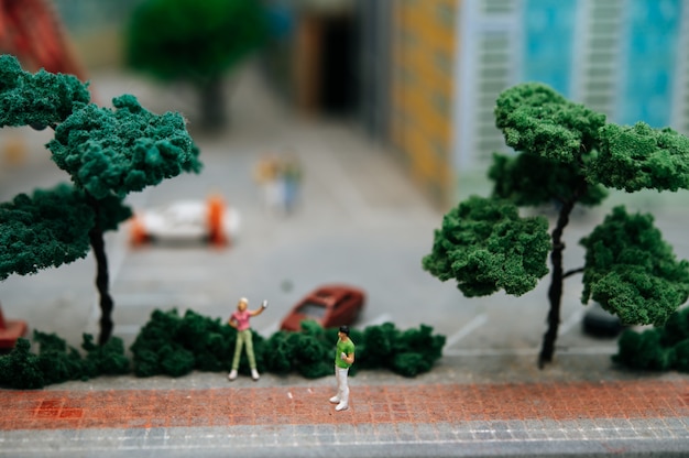Close up of small people or model people walking in the park.