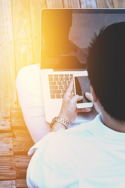 Close-up smart Business man wearing modern black suit and white shirt and texting on mobile smart phone with flare light.