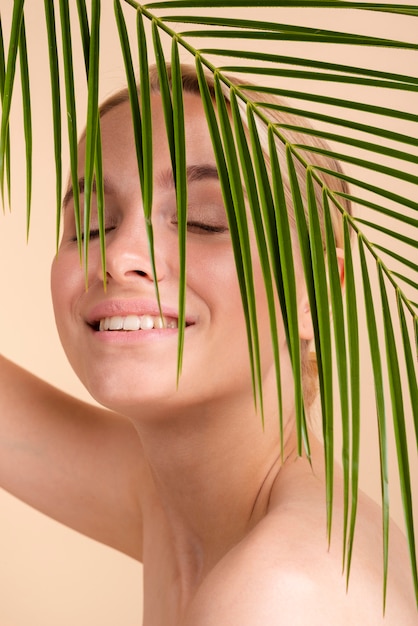 Close-up smiley blonde woman with leaves