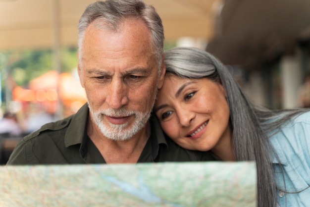 Close up smiley couple holding map