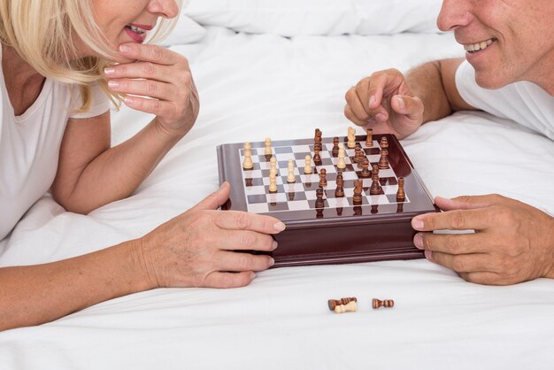 Close-up smiley couple playing chess