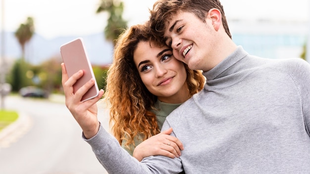 Close-up smiley couple taking selfie outdoors