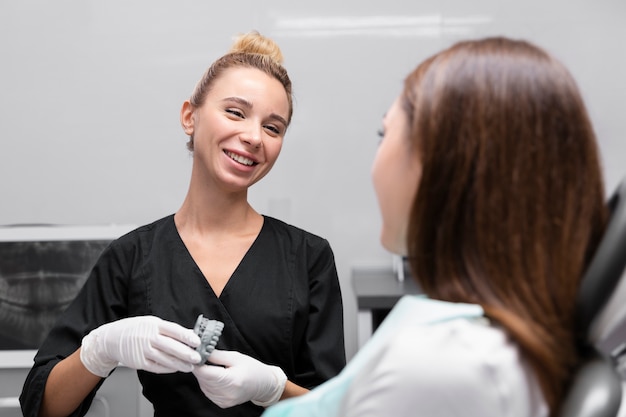 Dentista e paziente sorridenti da vicino