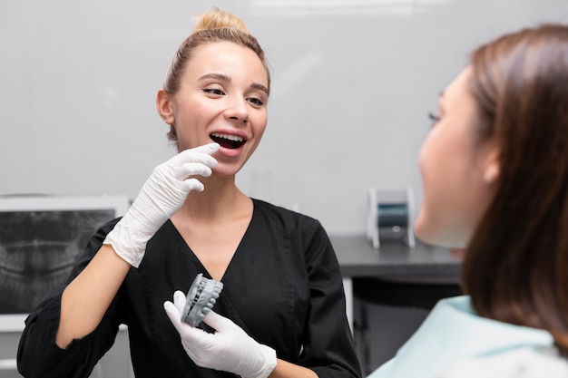 Крупным планом улыбающийся стоматолог и пациент