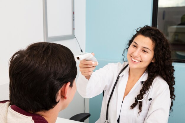 Close-up smiley doctor examining patient