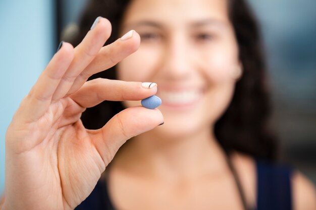 Close-up smiley doctor holding a pill