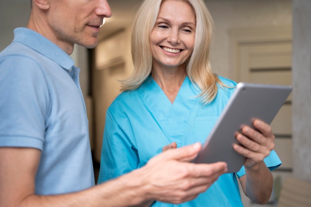 Free photo close up smiley doctor holding tablet