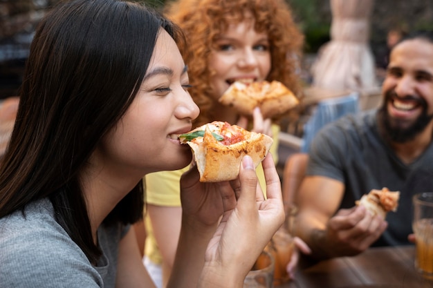 Close up smiley friends eating pizza