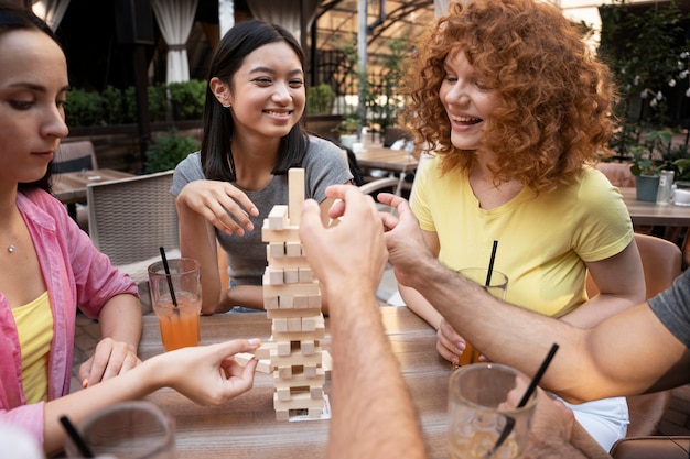 Free photo close up smiley friends playing game at table