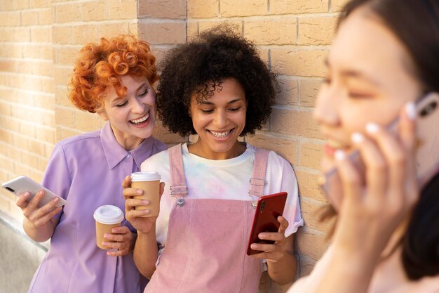 Close up smiley friends with smartphones