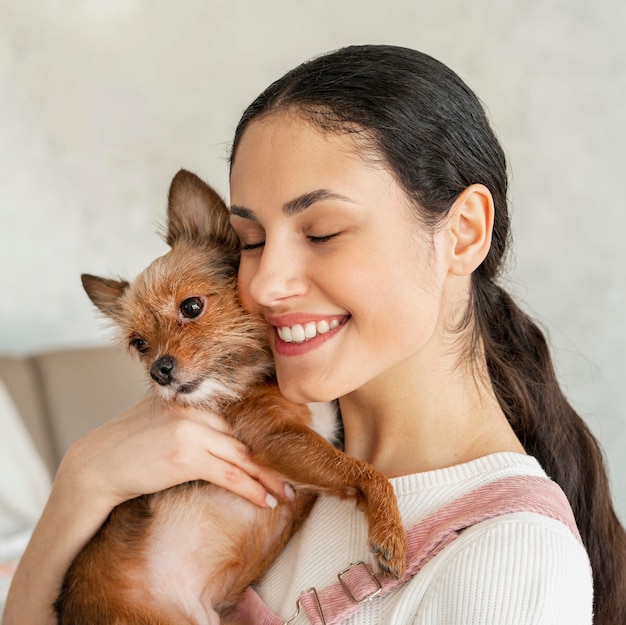 Foto gratuita ragazza di smiley del primo piano che abbraccia l'animale domestico