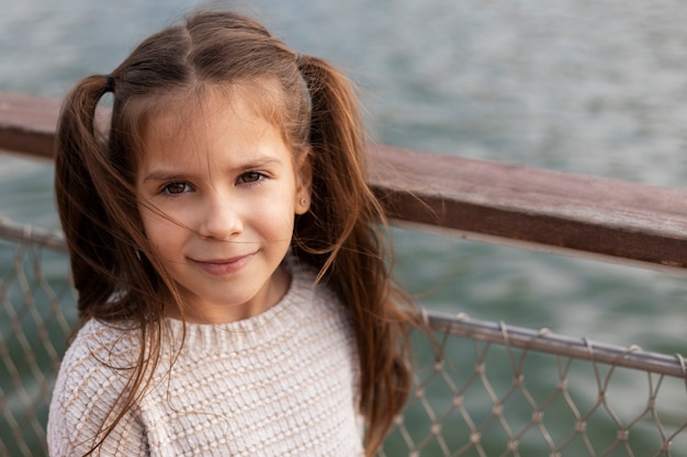 Free photo close up smiley girl at seaside