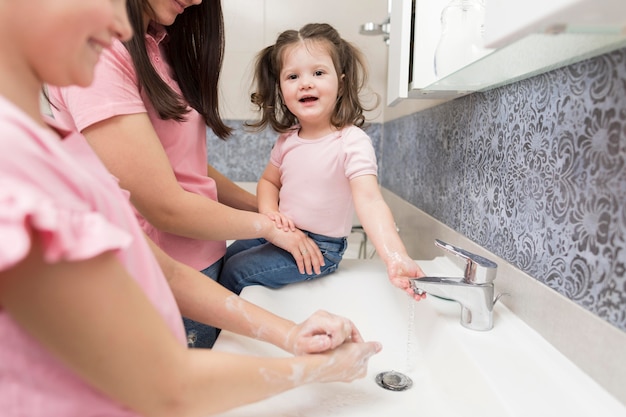 Close-up smiley girls washing hands