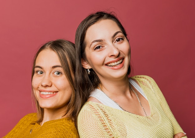 Close-up smiley girls with red background