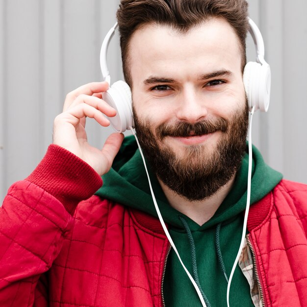 ひげとヘッドフォンのクローズアップスマイリー男