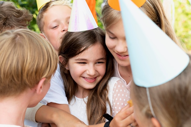 Close up smiley kids wearing party hats