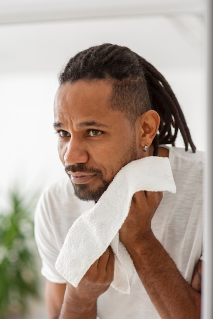 Free photo close up smiley man cleaning face