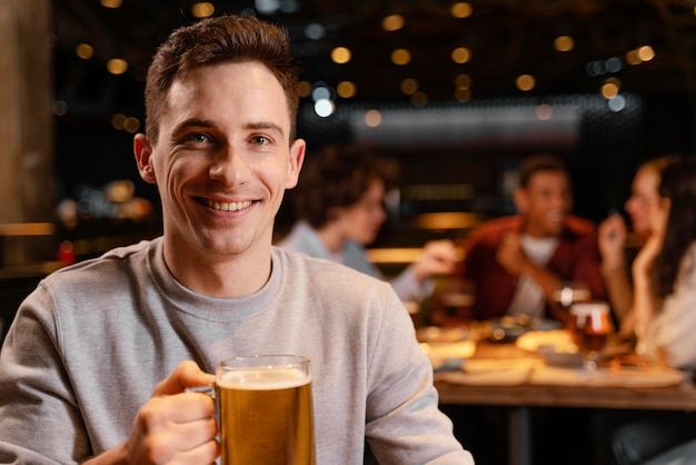 Close-up smiley man holding beer mug