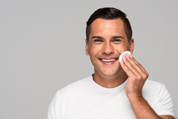 Close-up smiley man holding cotton pad