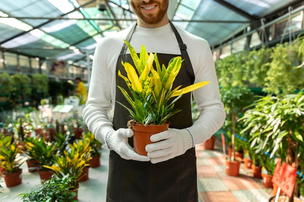 Free photo close up smiley man holding plant