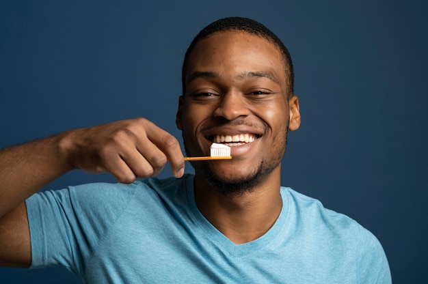 Крупным планом смайлик мужчина держит зубную щетку