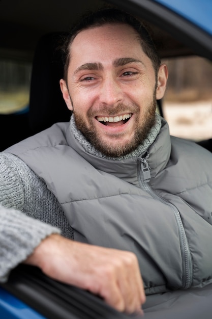 Foto gratuita primo piano dell'uomo sorridente all'interno dell'auto