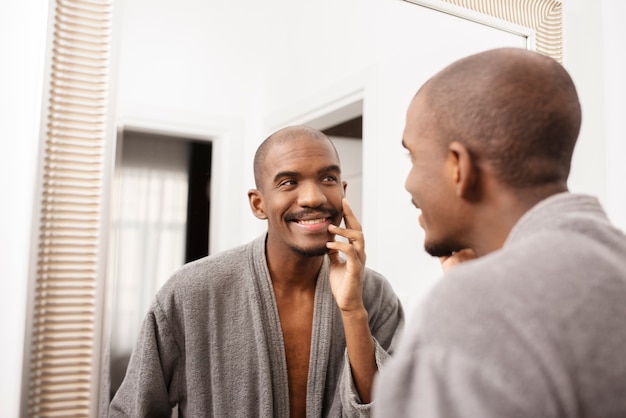 Free photo close up smiley man looking in mirror