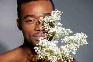 Foto gratuita uomo di smiley del primo piano che posa con i fiori