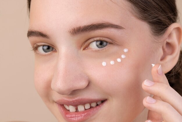 Close up smiley model using eye cream