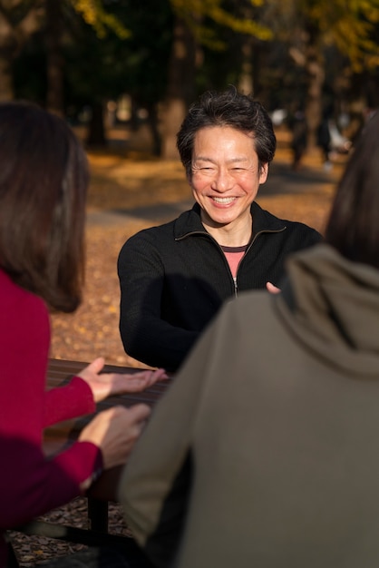 무료 사진 야외에서 웃는 수석 친구를 닫습니다