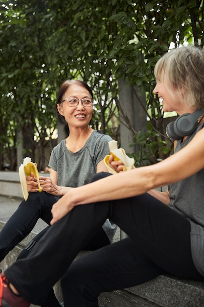 Free photo close up smiley senior women with bananas