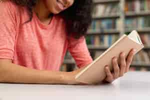 Free photo close-up smiley teenage girl reading