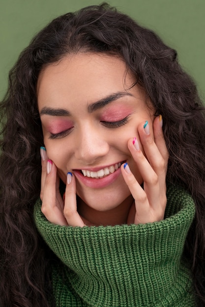 Бесплатное фото Крупным планом улыбающаяся женщина и красочный маникюр